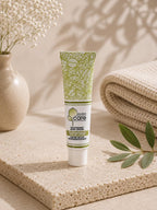 Tube de crème bleue régénérante Jojoba Care sur un support minéral avec fleurs blanches.