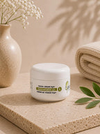 Crème de visage légère Jojoba Care dans un pot blanc sur un socle en pierre naturelle.