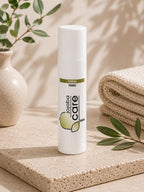 Flacon de soin Floral Tonic Jojoba Care posé sur un socle naturel avec une plante.